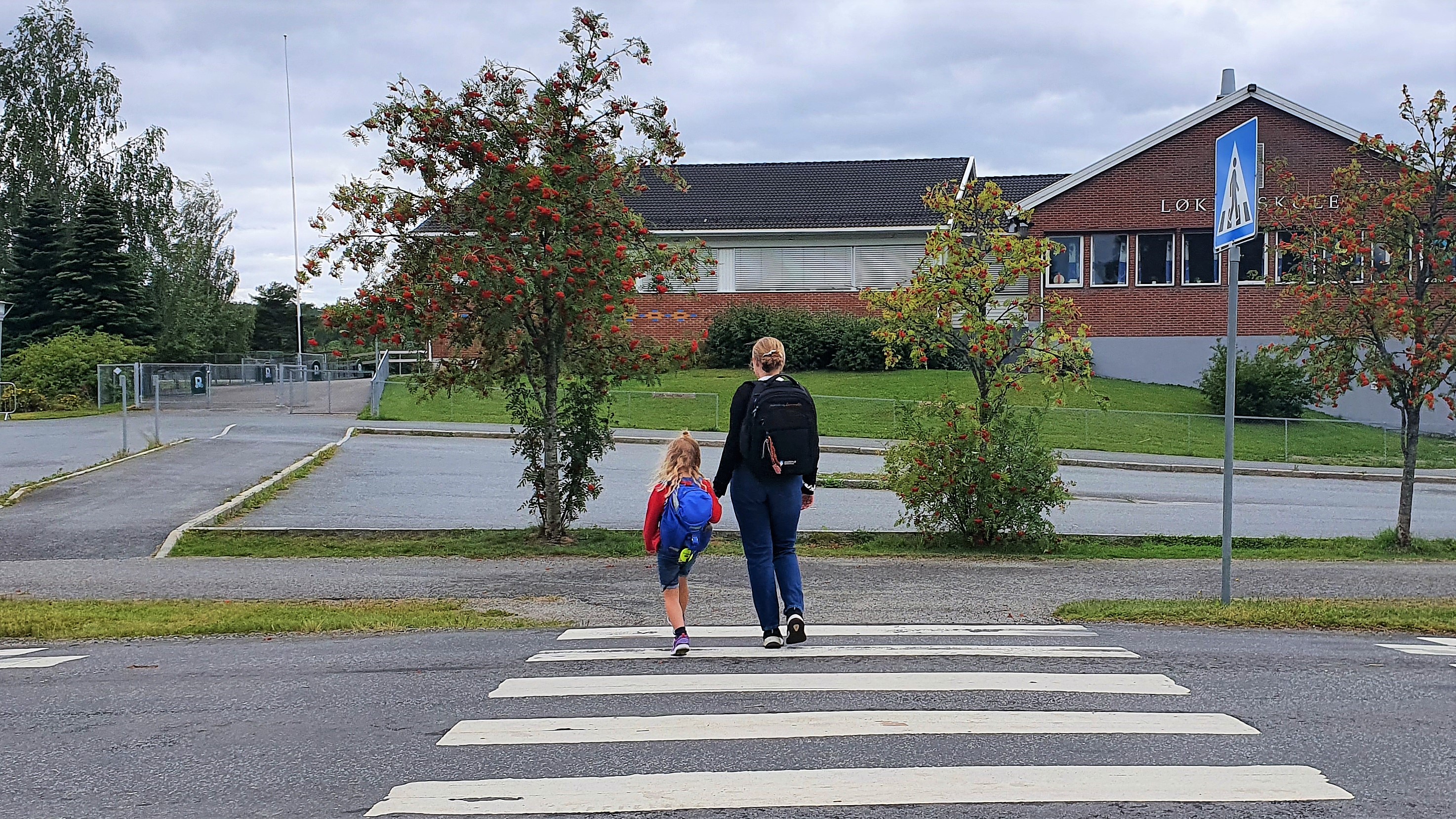 to barn som krysser en vei ved en skole